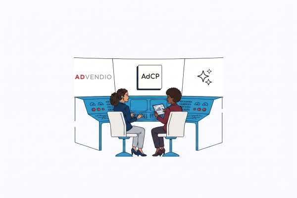 Due professionisti sono seduti davanti a una console di controllo blu e discutono guardando un tablet, con il logo AdCP appeso alla parete.